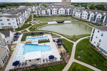An aerial view of a resort with a swimming pool and a pond.